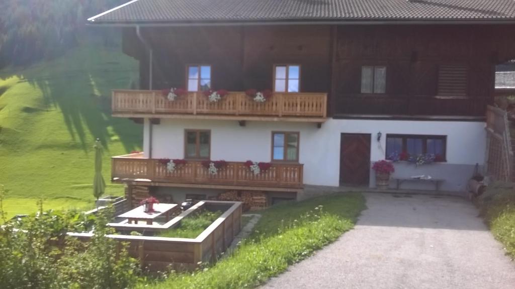 a house with a balcony and a garden in front of it at Ferienhaus Egger in Innervillgraten