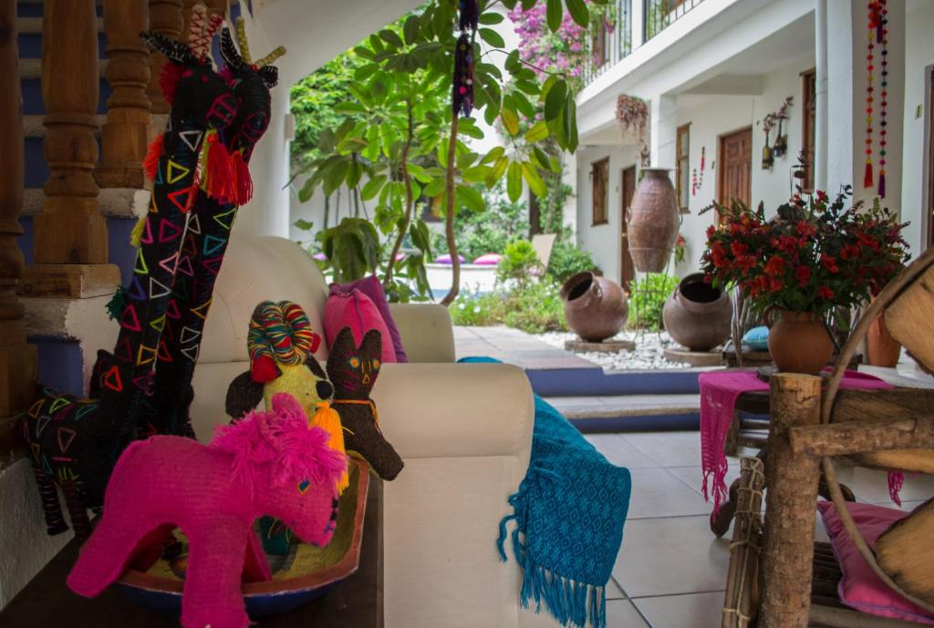 Un sofá con un caballo de juguete rosa. en Hotel Casa Mia en San Cristóbal de Las Casas