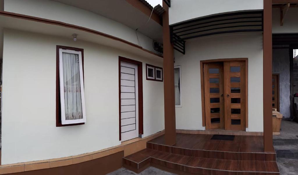 a house with a wooden door and some stairs at Bromo Deddy Homestay in Bromo