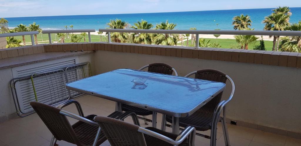 una mesa y sillas en un balcón con vistas a la playa en Apartamentos Danesp-Playa de les Amplaries Marina Dor- Frontales al Mar, en Oropesa del Mar