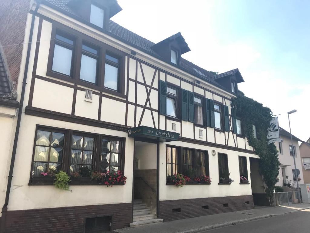 ein weißes und schwarzes Gebäude mit Blumen in den Fenstern in der Unterkunft Hofreit am Bierkeller in Kehl am Rhein