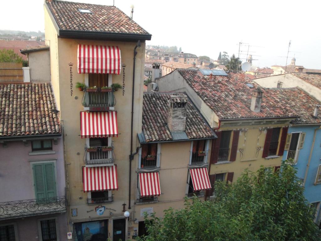 a building with red and white striped awnings and roofs at The Tower Of The Old King in Desenzano del Garda