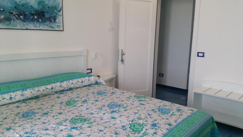 a bedroom with a bed with a floral bedspread at Casa Vacanze Parco Del Generale in Ischia