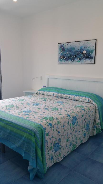 a bedroom with a bed with a floral comforter at Casa Vacanze Parco Del Generale in Ischia
