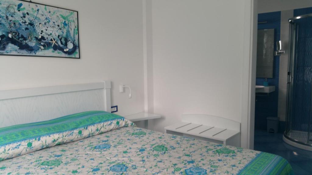 a bedroom with a bed and a painting on the wall at Casa Vacanze Parco Del Generale in Ischia