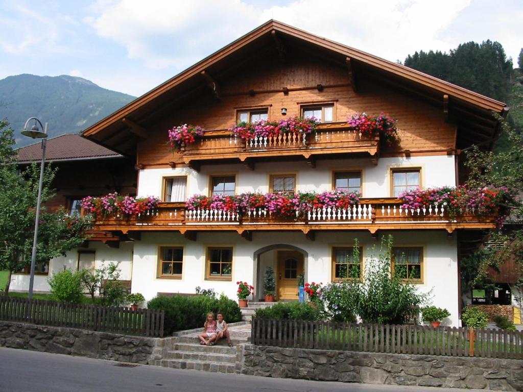 uma casa com flores na varanda em Bauernhof im Zillertal, der Badererhof em Stumm