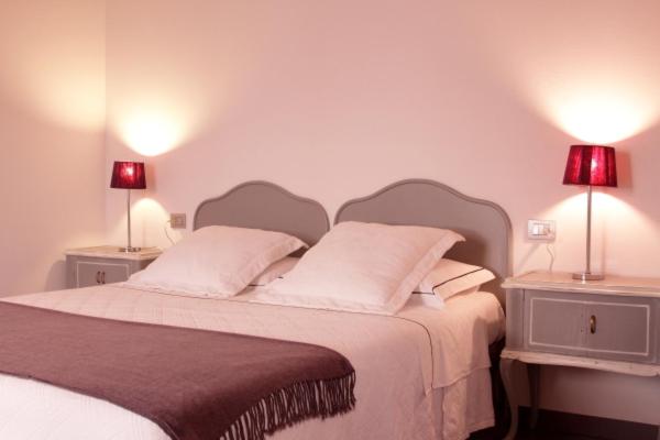a bedroom with a large bed with two lamps on it at Romeo e Giulietta Appartamenti in Parona di Valpolicella