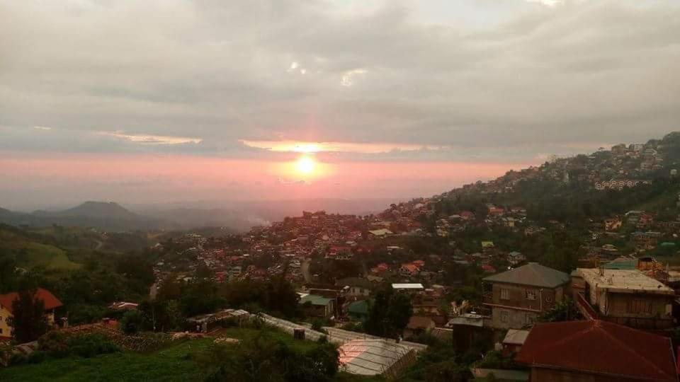 una vista de una ciudad con la puesta de sol en el fondo en Cool View Baguio City, en Baguio