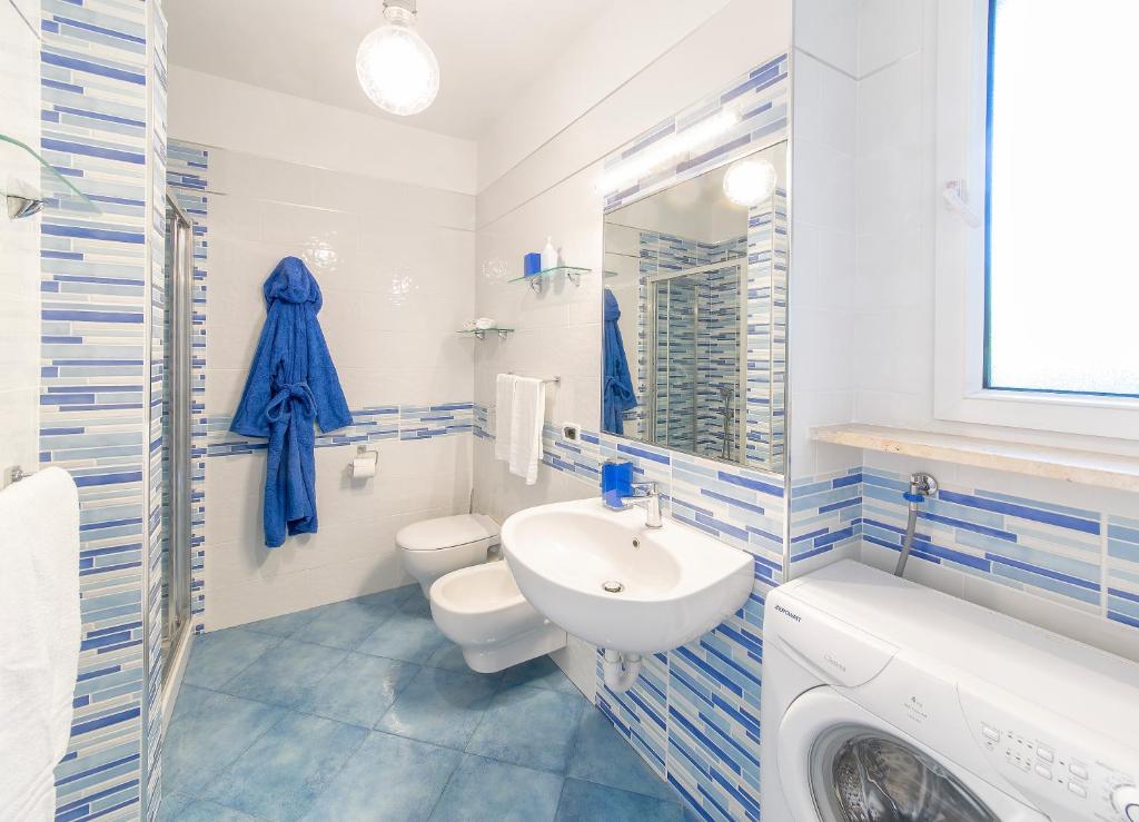 a bathroom with a sink and a toilet and a washing machine at Casa Vacanze Parco Del Generale in Ischia