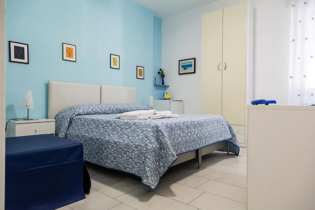 a bedroom with a bed with a blue wall at Aurora Sul Mare in Otranto