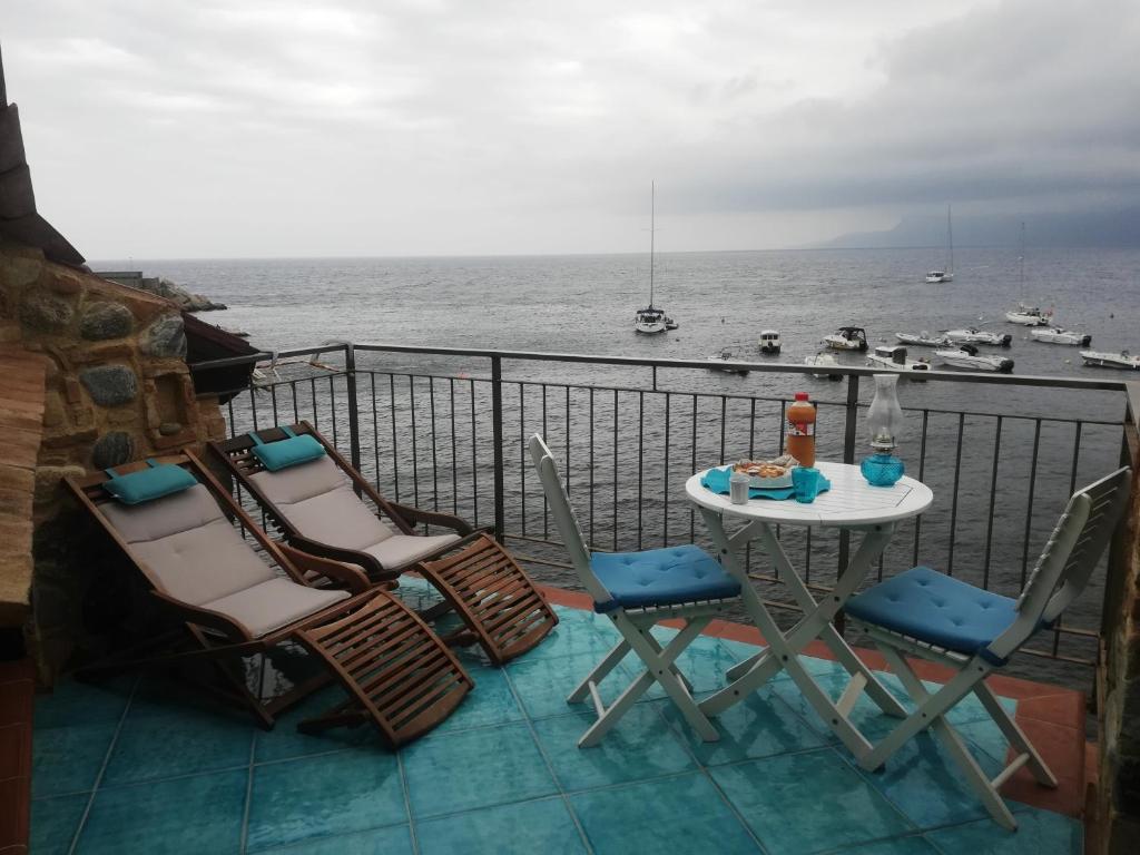 a table and chairs on a balcony overlooking the ocean at Casa il Soffio di Eolo in Scilla