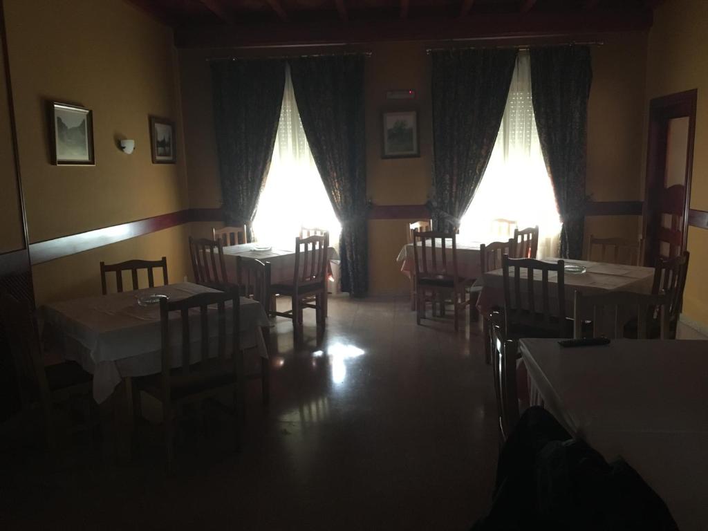 un comedor con mesas, sillas y luces en Hostal Moraleda ** en Piedrabuena