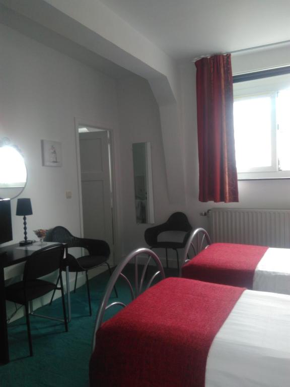 a hotel room with two beds and a table and chairs at Eurotel in Liège