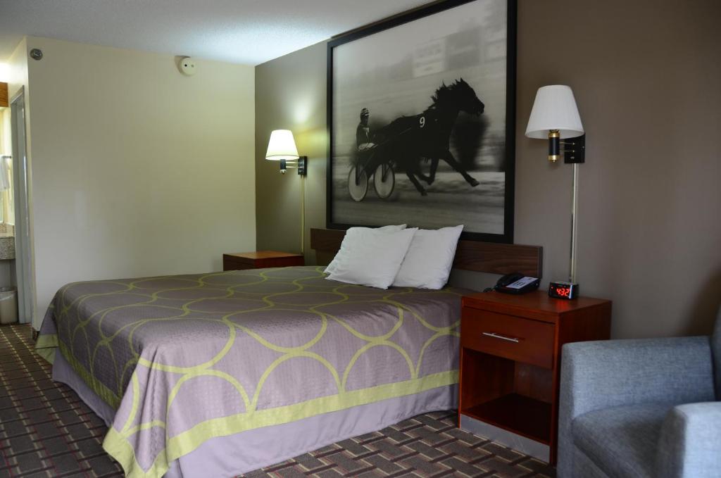 a hotel room with a bed and a picture of a horse at Super 8 by Wyndham Franklin Hwy 31 in Franklin