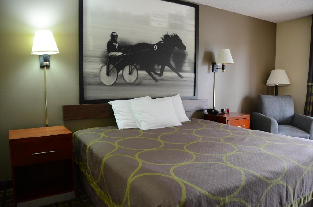 a hotel room with a bed and a horse painting on the wall at Super 8 by Wyndham Franklin Hwy 31 in Franklin