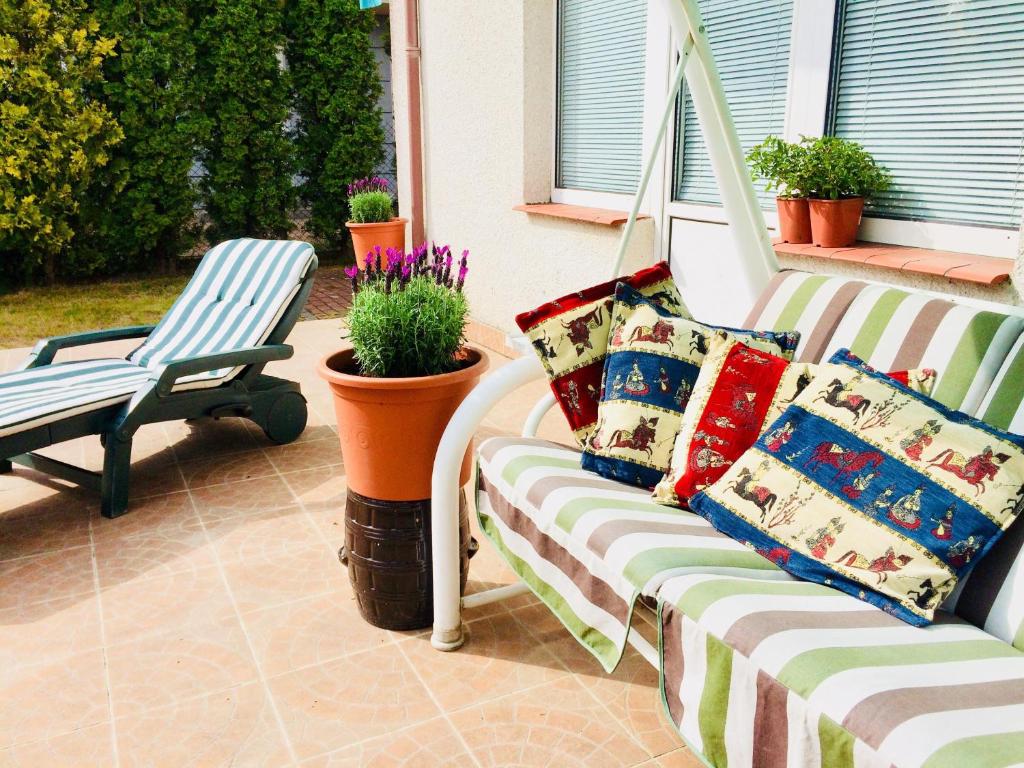 a porch with a couch and a chair and flowers at Arenda in Karwia