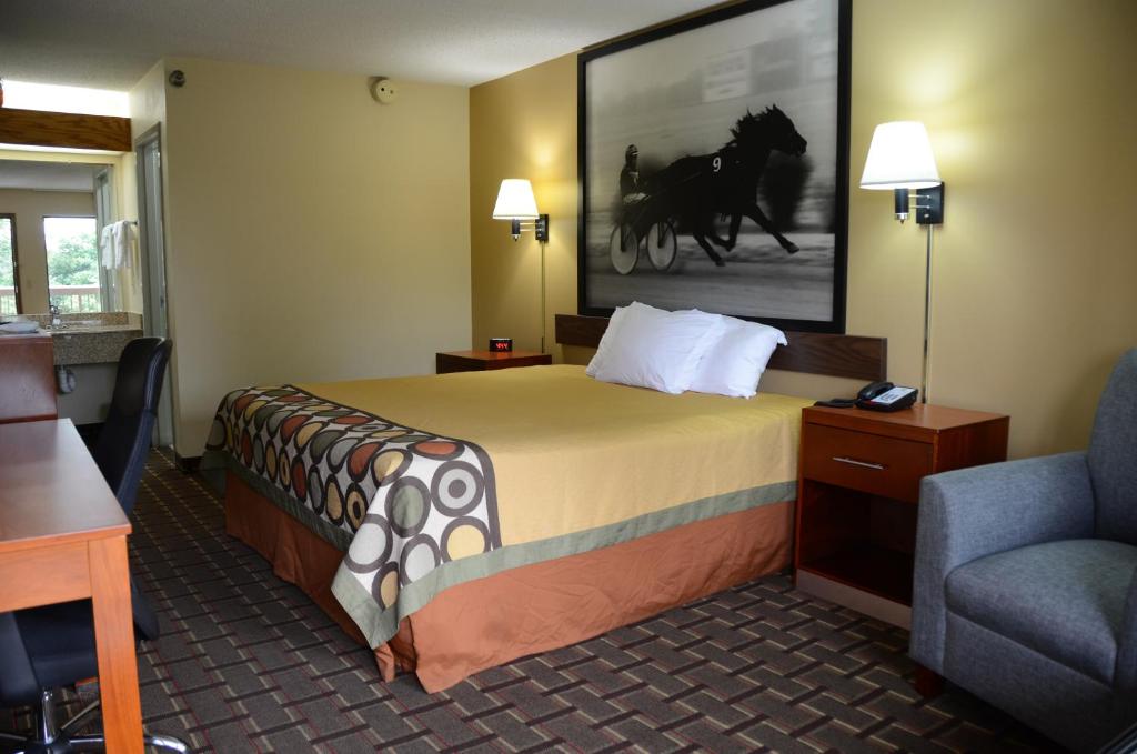 a hotel room with a bed and a chair at Super 8 by Wyndham Franklin Hwy 31 in Franklin