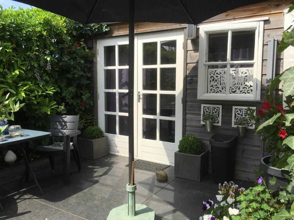 un patio con sombrilla frente a una casa en Studio@25, en Zandvoort