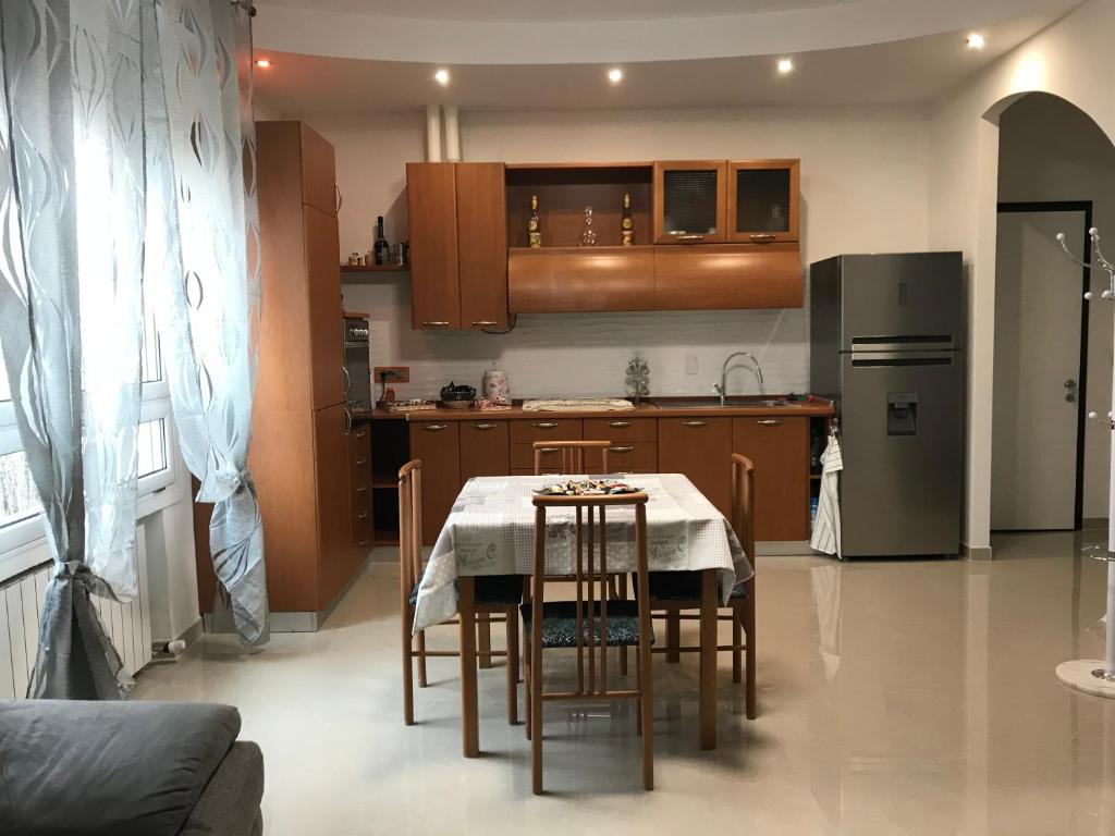 Una cocina con una mesa con sillas y un refrigerador. en B&B Appartamento Anna, en Bolonia