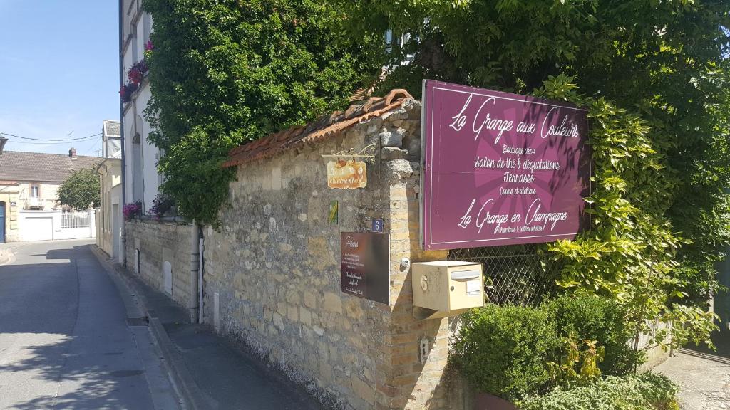 un edificio con un letrero púrpura en el costado. en La Grange en Champagne en Hermonville