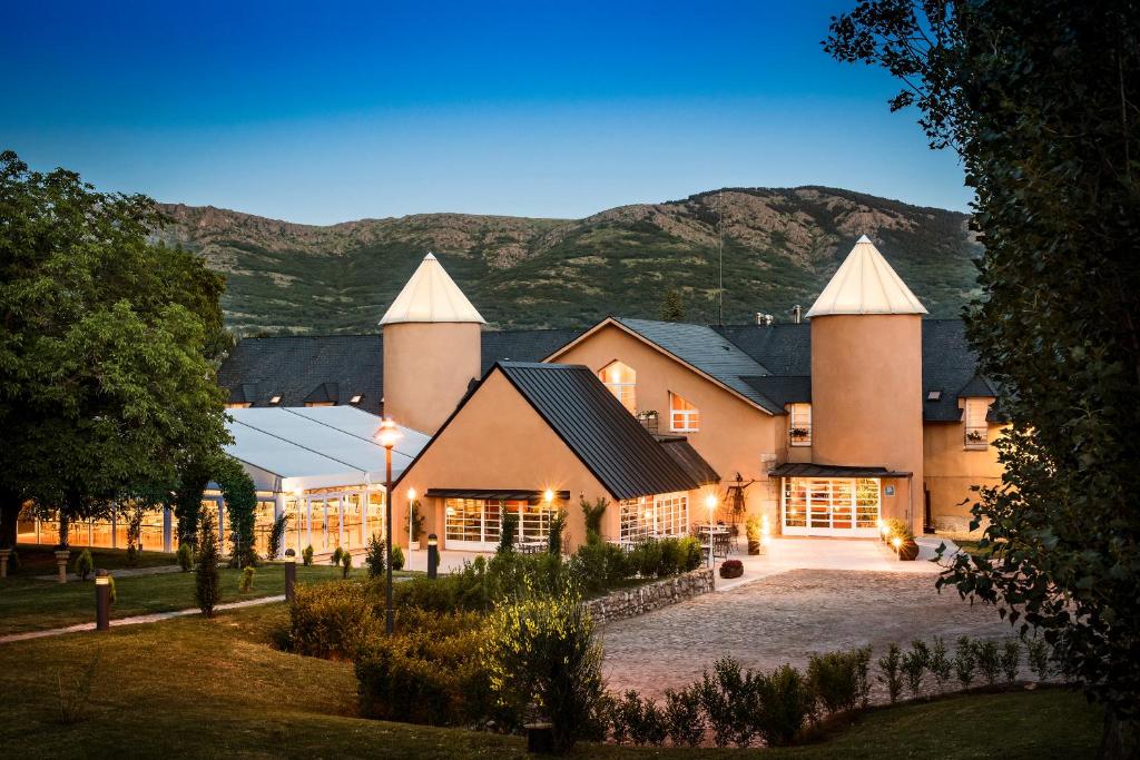 a large house with mountains in the background at Hotel La Posada De Alameda in Alameda del Valle