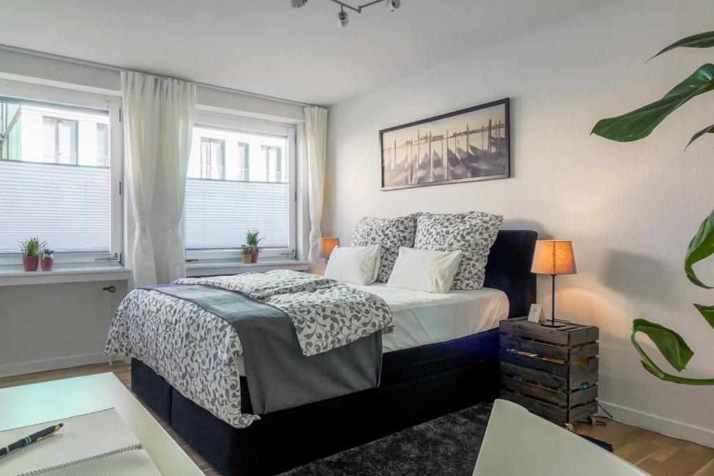 a bedroom with a bed and two windows at Apartments an der Universität in Wuppertal