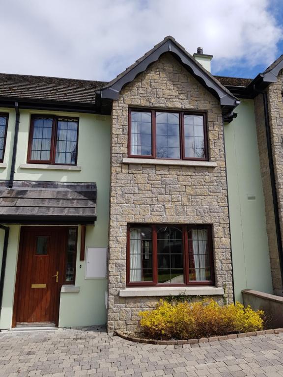 uma casa com uma porta castanha e janelas em Emerald Charm, Luxury Self Catering, Lough Rynn Castle Estate em Mohill