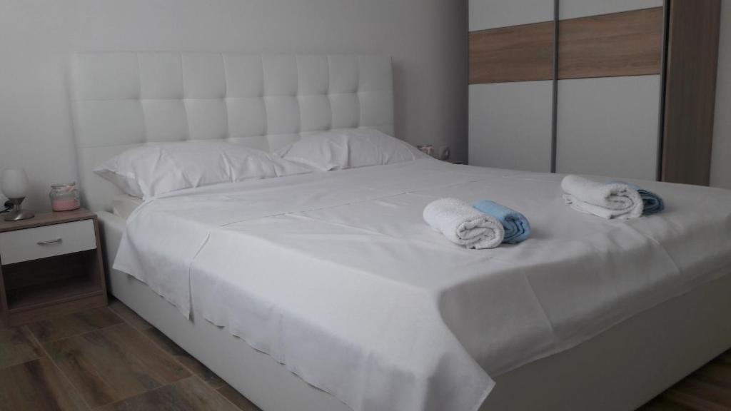a bedroom with a white bed with towels on it at Pearl apartments Pag in Pag