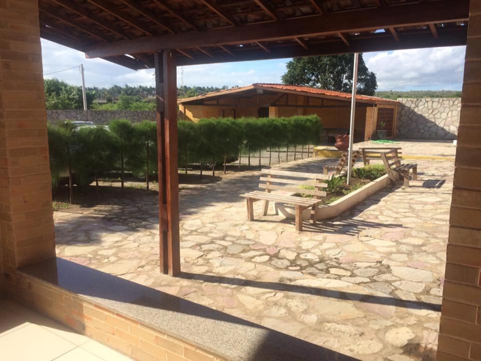 a group of benches sitting on a stone patio at Hotel Mirante do Vale in Itabaiana