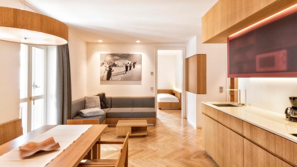 a kitchen and living room with a table and a couch at Apartment Genziana in Ortisei