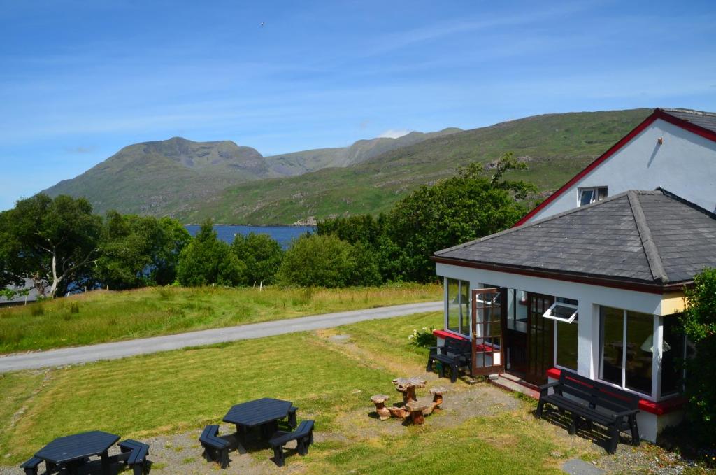 an aerial view of a house with mountains in the background at The Connemara Hostel - Sleepzone in Leenaun
