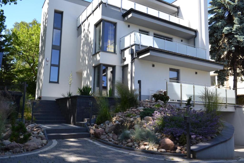 a white house with a garden in front of it at Apartamenty Willa Nawigator in Gdynia