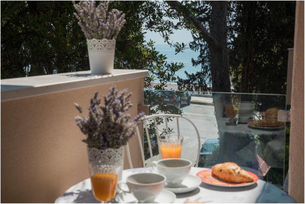 a table with a plate of food and drinks on a balcony at Izzy apartment in Split