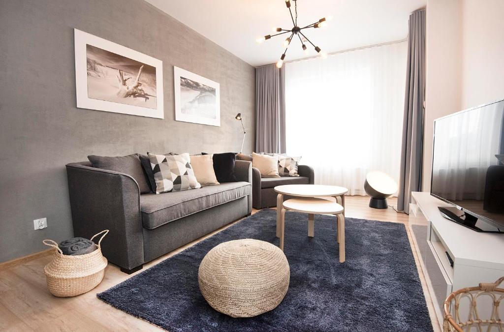 a living room with a couch and a table at LATO apartament Polanki Park z miejscem parkingowym in Kołobrzeg