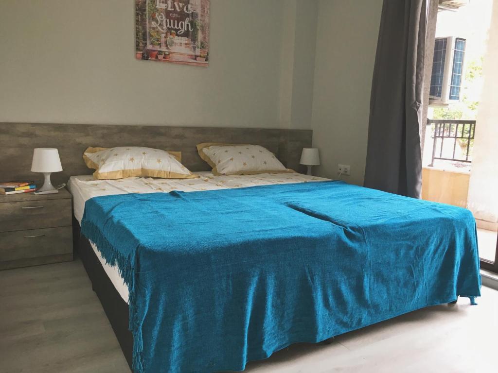 a bedroom with a bed with a blue blanket on it at Azzurro Apartment - ideal for your seaside escape in Burgas in Burgas
