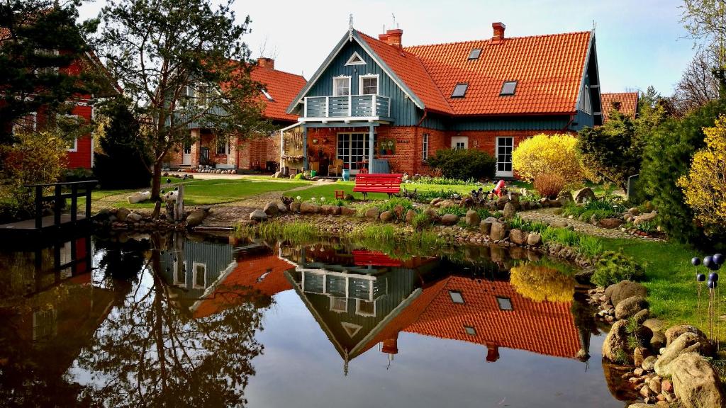 a large house with a pond in front of it at Provincija in Palanga