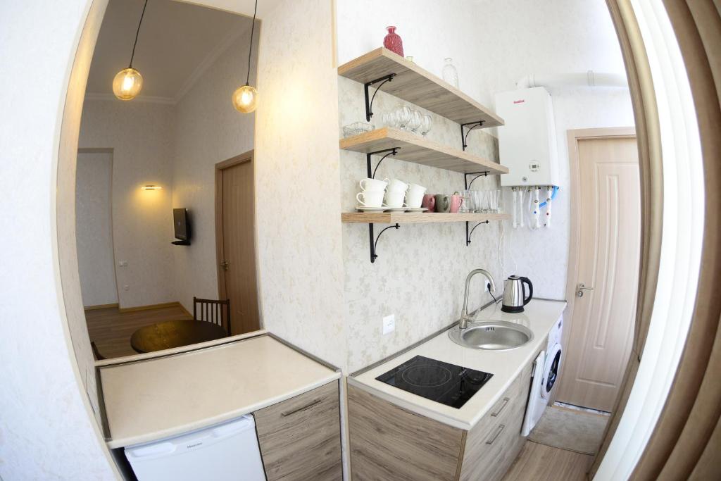 - une petite cuisine avec un évier et un miroir dans l'établissement Ana's Apartment in Old Tbilisi, à Tbilissi