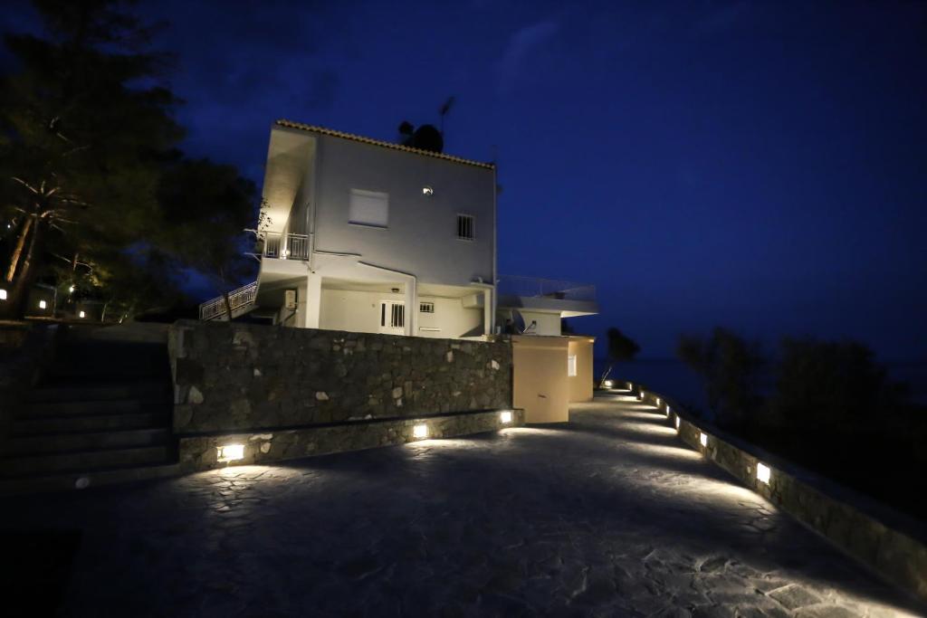 a house with lights on the side of it at night at Skouros Villa in Kastrí