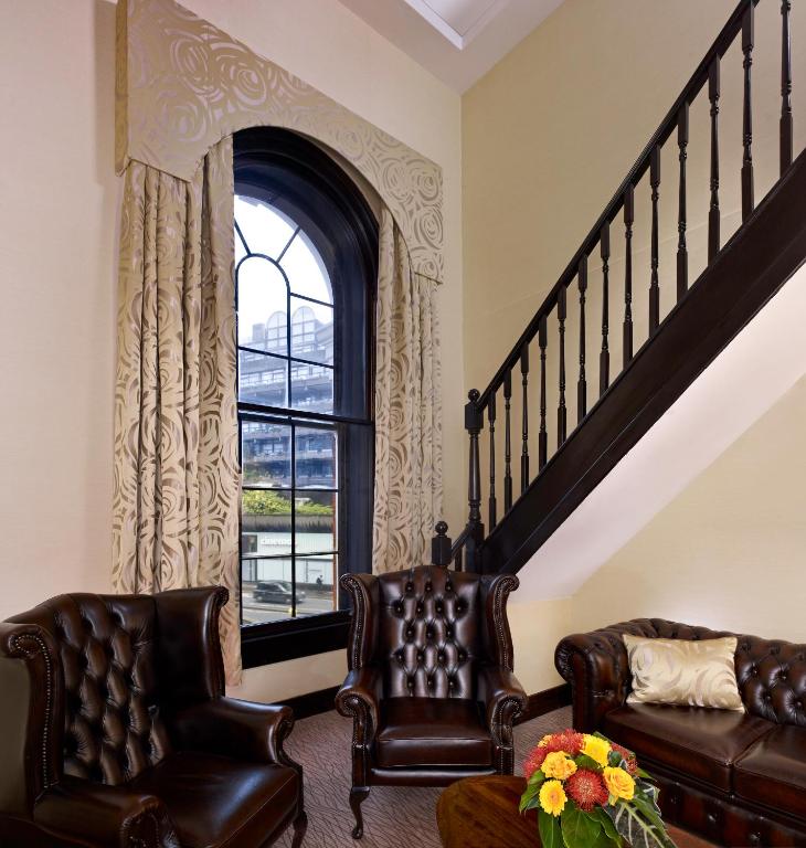 a living room with two leather chairs and a window at Montcalm Brewery, London City in London