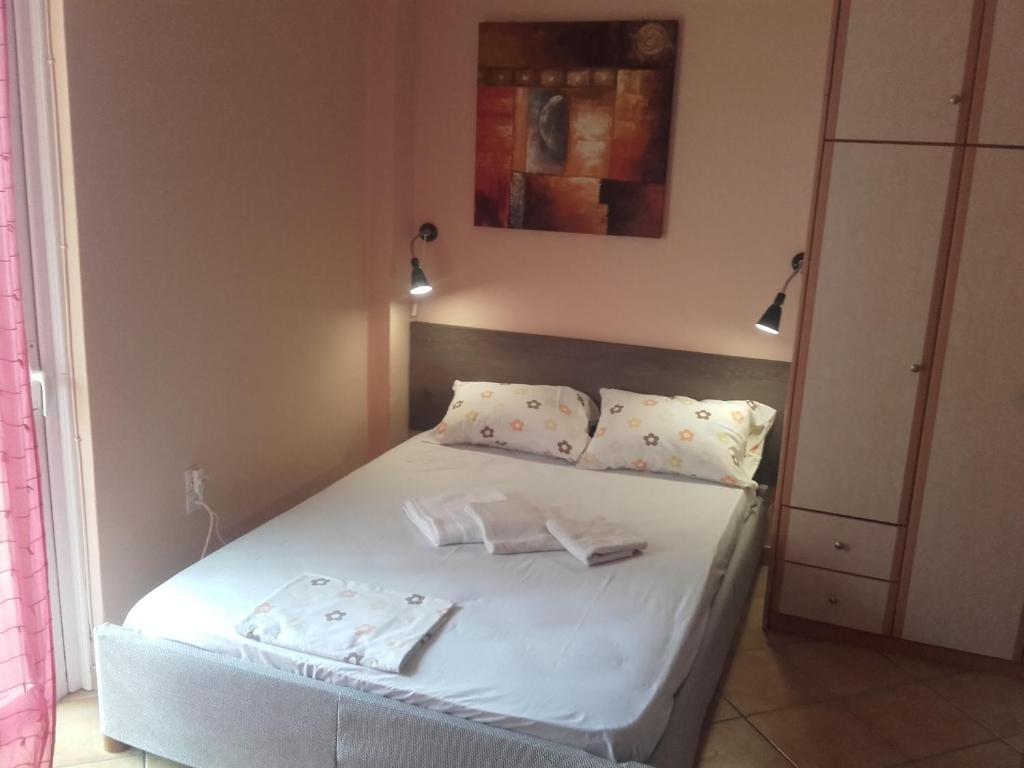 a bedroom with a bed with white sheets and pillows at Chris Apartment in Preveza