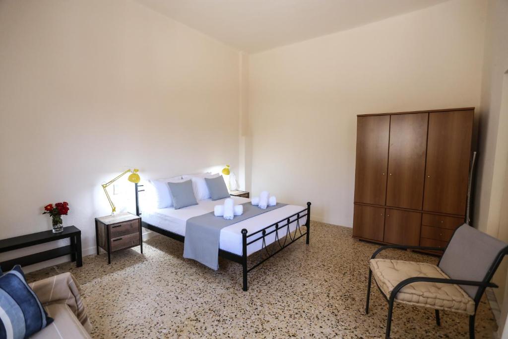 a bedroom with a bed and a chair and a cabinet at Skouros Villa in Kastrí