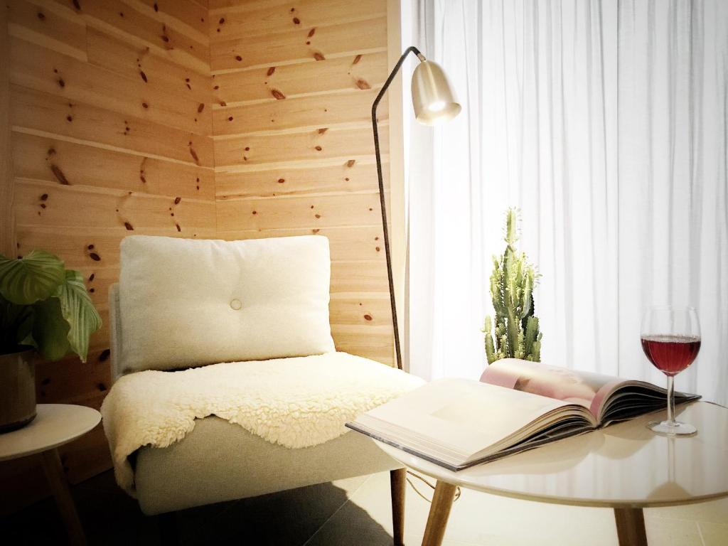 a room with a table with a book and a glass of wine at Tromsø City Apartments in Tromsø