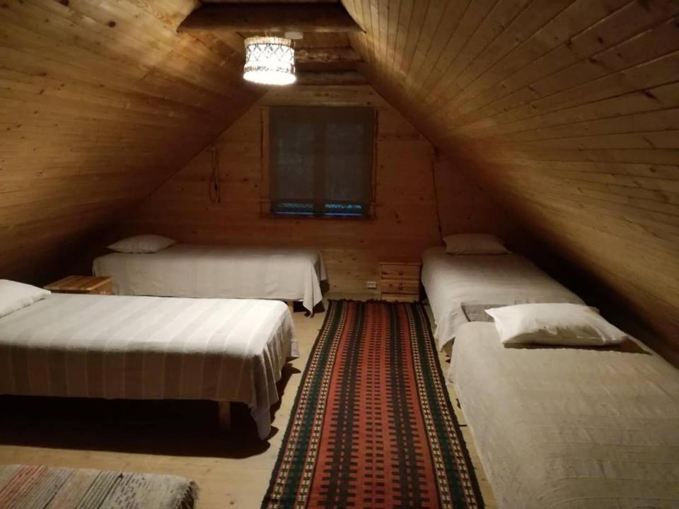 a room with two beds in a wooden cabin at Ala Juusa Holiday Home in Ihamaru