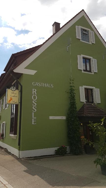 a green building with a sign on the side of it at Hotel Gasthaus Rössle in Freiburg im Breisgau