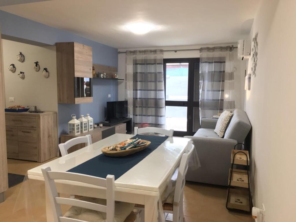 une cuisine et un salon avec une table et des chaises dans l'établissement Casamare Lido di Noto, à Noto Marina