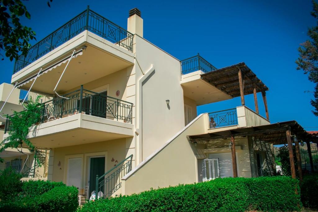 un edificio de apartamentos con balcones y arbustos en Anavyssos Cottage, en Palaia Fokaia