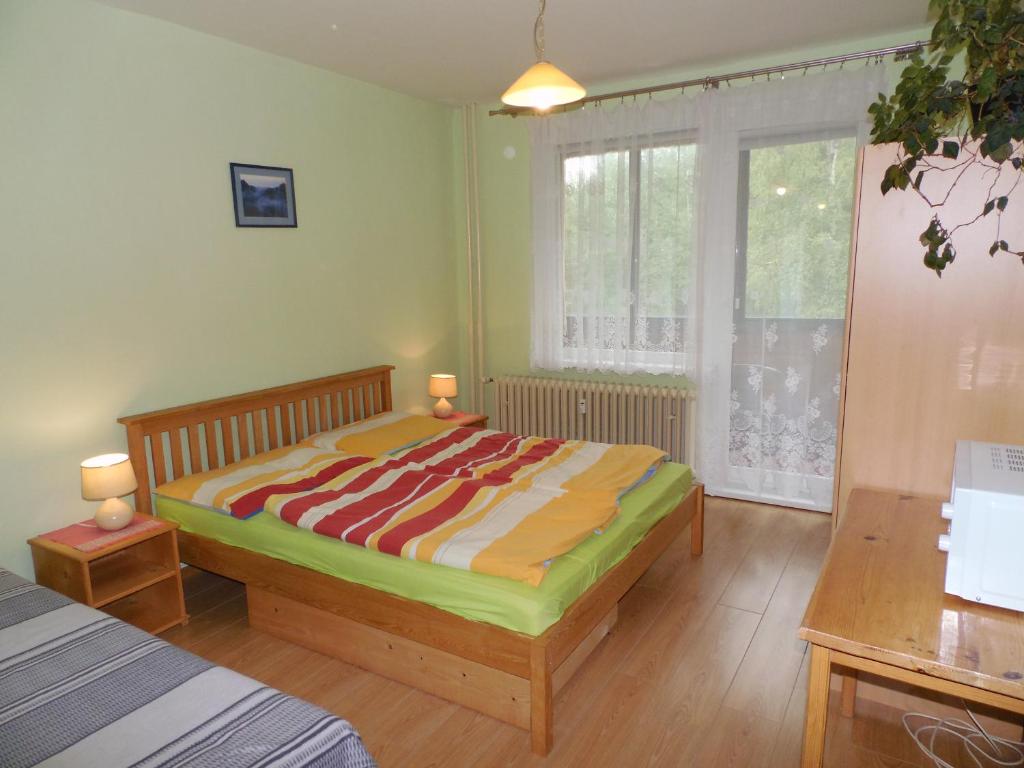 Apartmán Zdravie Horný Smokovec في Vysoke Tatry - Horny Smokovec: غرفة نوم بسرير وطاولة ونافذة