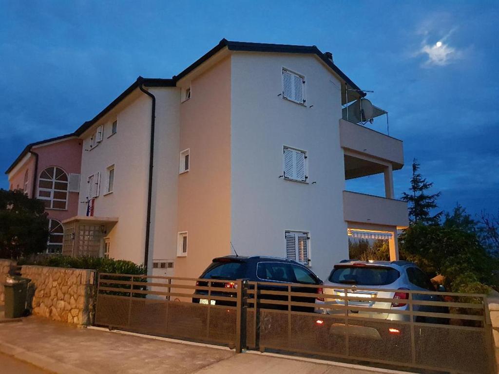 two cars parked in front of a building at Apartments Vučko in Povile