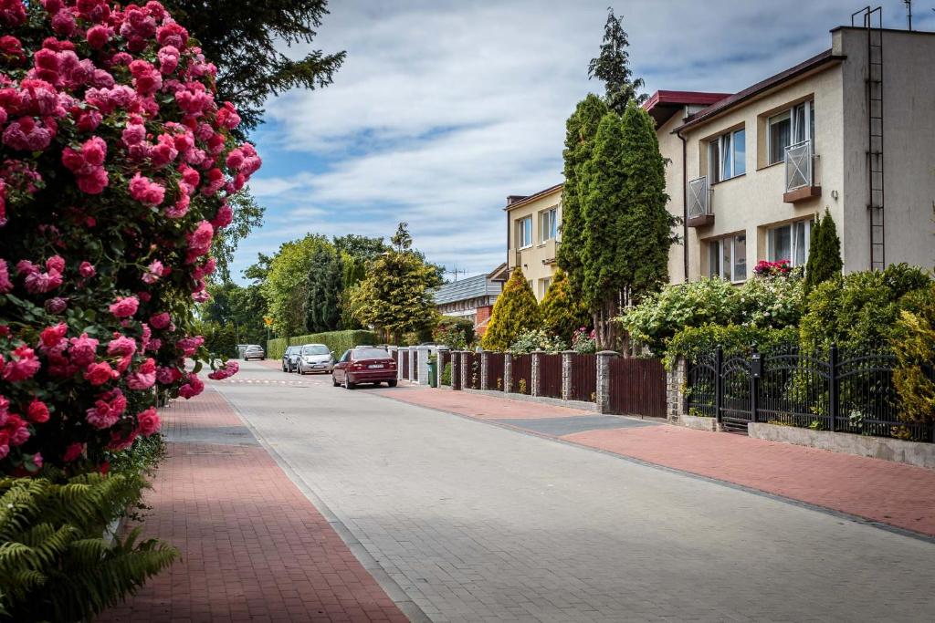 Une rue avec des fleurs roses sur le côté d'une route dans l'établissement SunSet, à Mielno