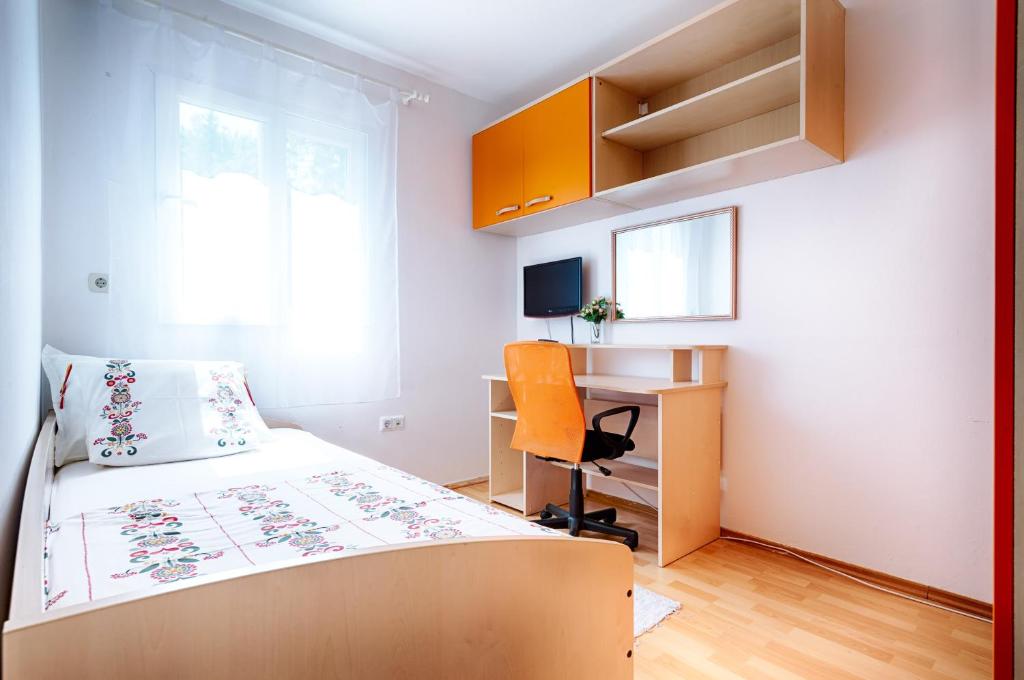 a bedroom with a bed and a desk and a chair at Apartman Prošperino in Vis